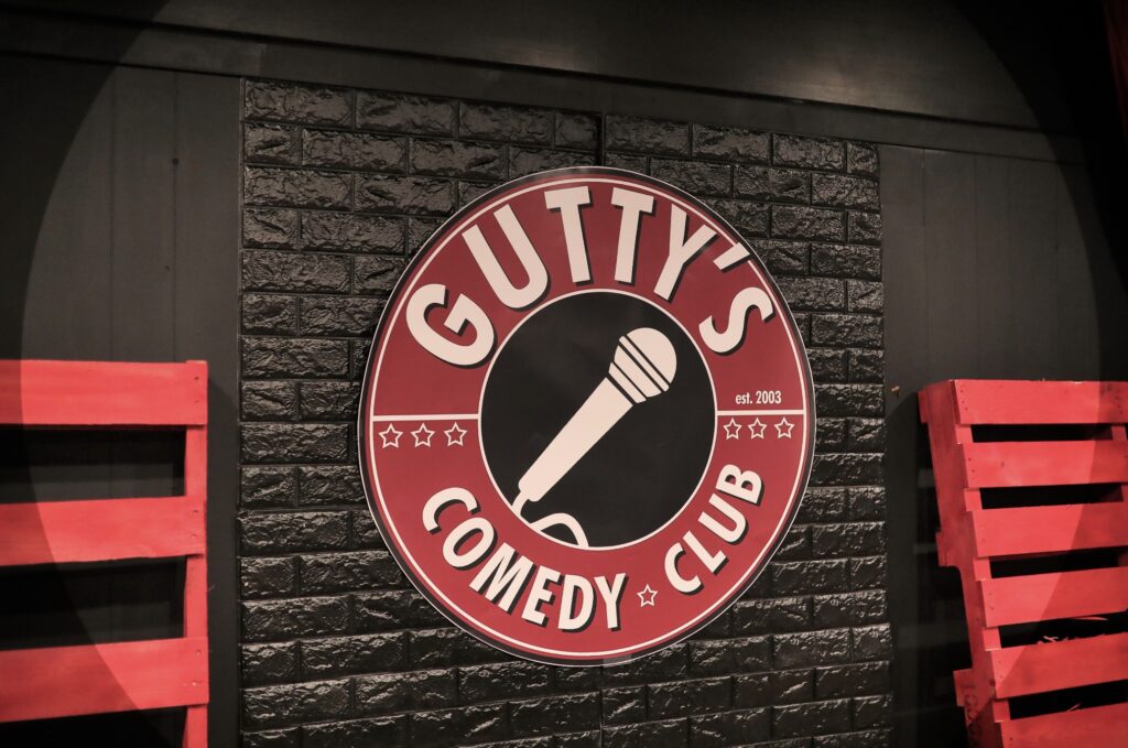 Photo of a sign that reads Gutty's Comedy Club